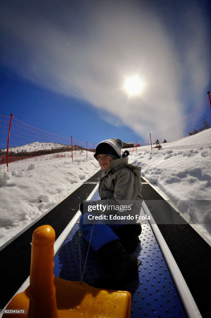 Boy rides 'magic carpet' ski escalator