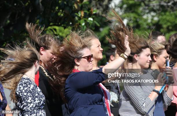 Visitors to the White House wave as US President Donald Trump and First Lady Melania board the Marine One helicopter July 25, 2017 in Washington, DC....