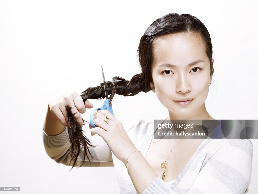 Young asian woman about to cut her hair