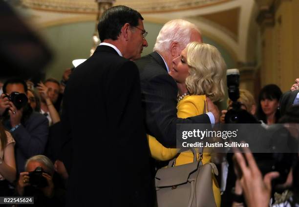 Cindy McCain, wife of U.S. Sen. John McCain hugs U.S. Sen. John Cornyn and U.S. Sen. John Barrasso during a news conference on Capitol Hill following...