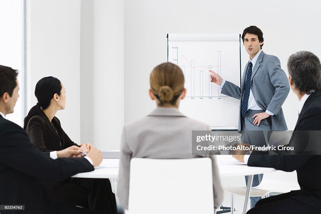 Businessman making presentation, colleagues watching
