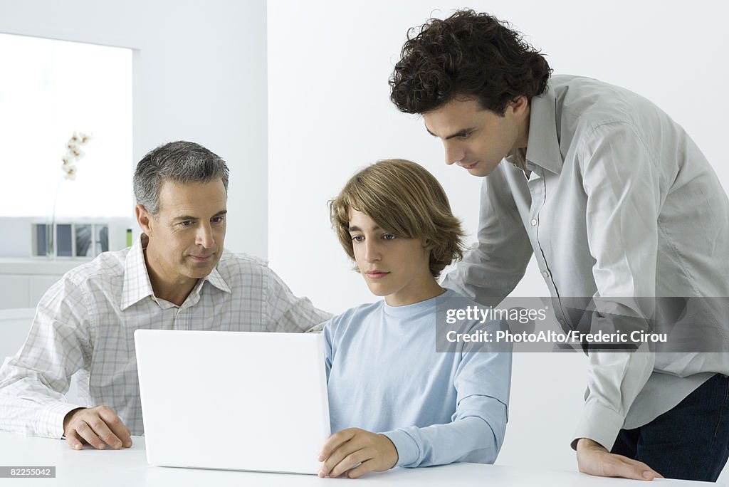 Garoto adolescente com pai e o irmão mais velho, olhando