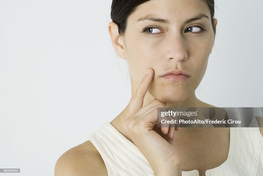 Woman looking away, hand under chin