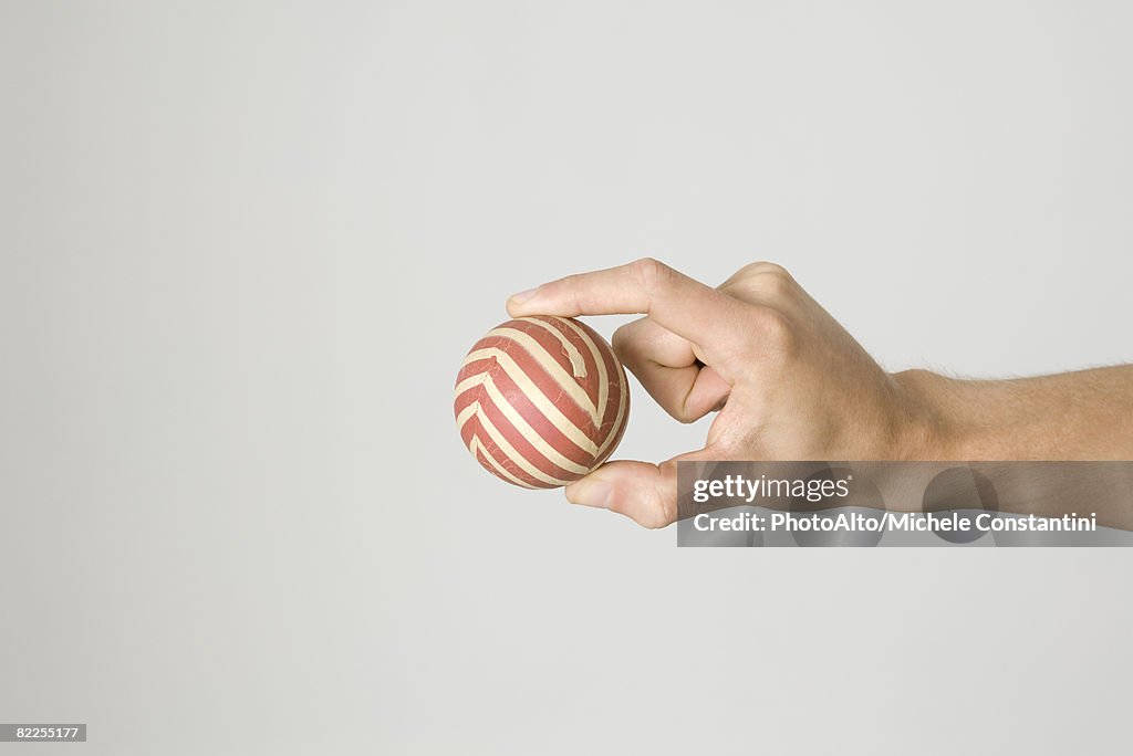 Hand holding striped ball
