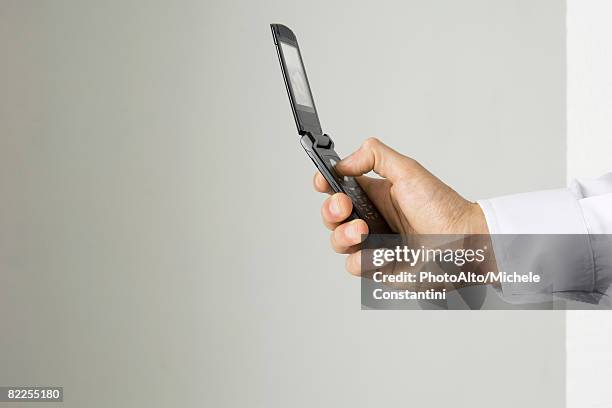 hand holding cell phone, side view - feature phone stockfoto's en -beelden