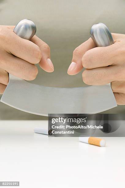 person cutting cigarette in half with meat cleaver, cropped view of hands - mincing knife stock pictures, royalty-free photos & images