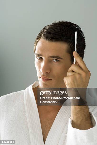 man combing hair, looking at camera, portrait - man combing hair stock pictures, royalty-free photos & images