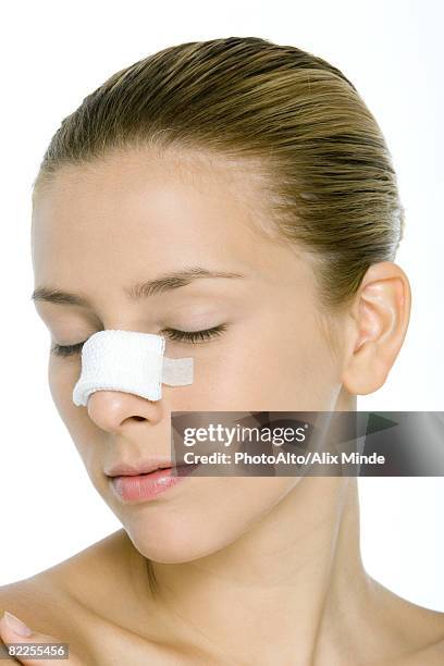 young woman with bandaged nose, eyes closed - nasenkorrektur stock-fotos und bilder