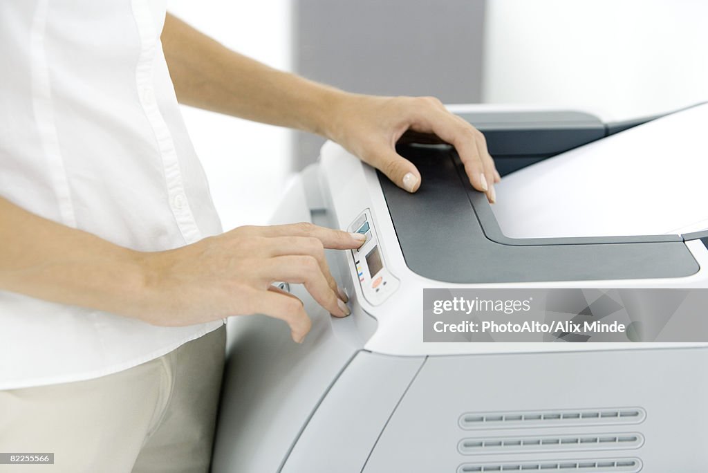 Female using photocopier, cropped view