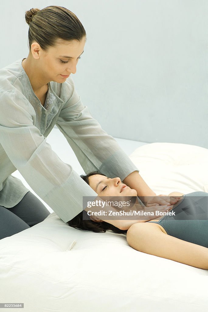 Massage therapist giving woman chest massage