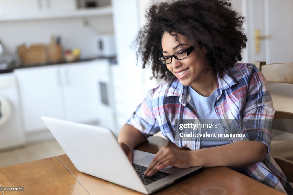 Frau mit Brille mit Laptop zu Hause