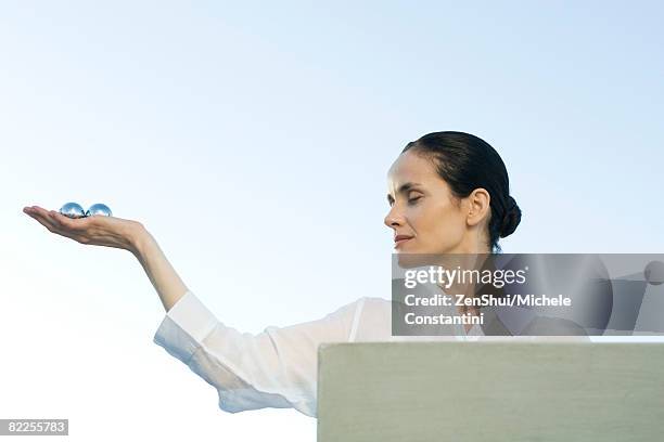 woman holding out yin yang balls in palm of hand - stress ball stock pictures, royalty-free photos & images