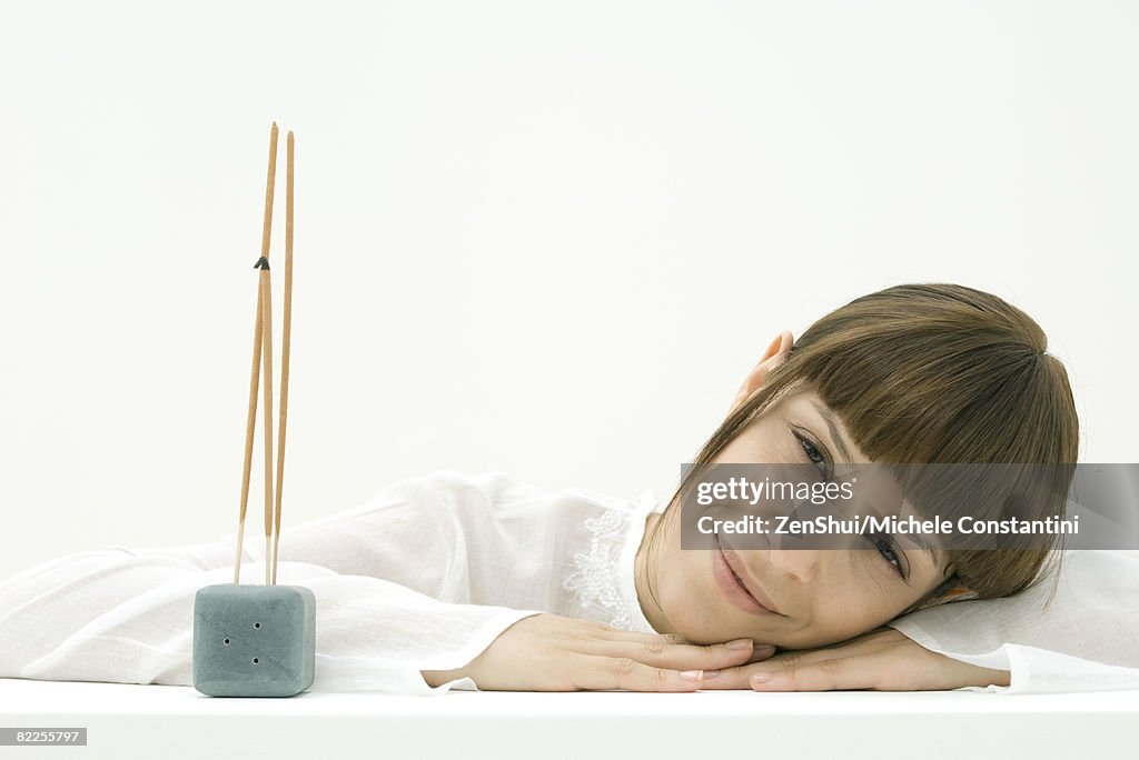 Woman with incense, smiling at camera