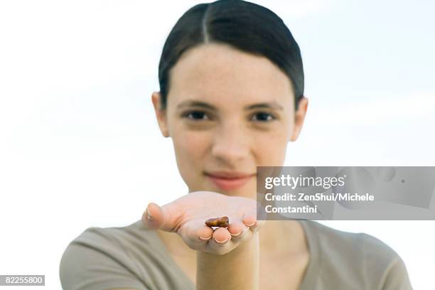 young woman holding out dried bean in palm of hand - northern european descent stockfoto's en -beelden