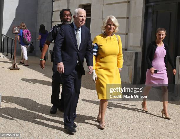 Sen. John McCain and his wife Cindy McCain walk out of the Russell Senate Office building toward their car at the US Capitol July 25, 2017 in...