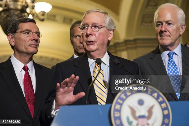 Senate Majority Leader Mitch McConnell speaks with US Senators John Barrasso , John Cornyn and John Thune after the Senate narrowly passed the...