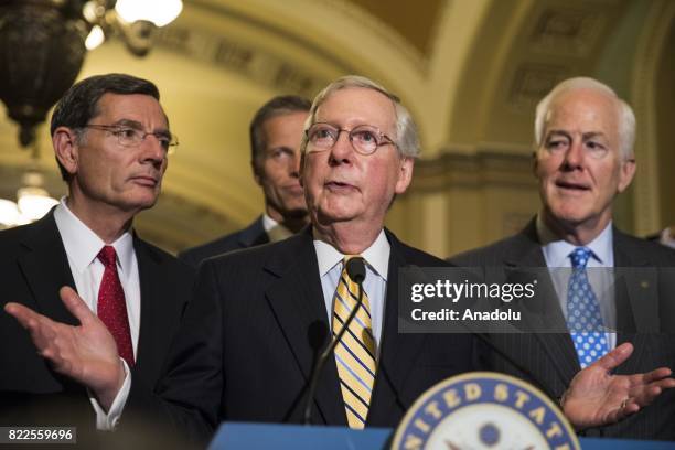 Senate Majority Leader Mitch McConnell speaks with US Senators John Barrasso , John Cornyn and John Thune after the Senate narrowly passed the...