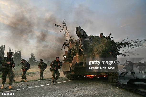 Georgian soldiers escape their burning armoured vehicle on the road to Tbilisi on August 11, 2008 just outside Gori, Georgia. Russia called today for...