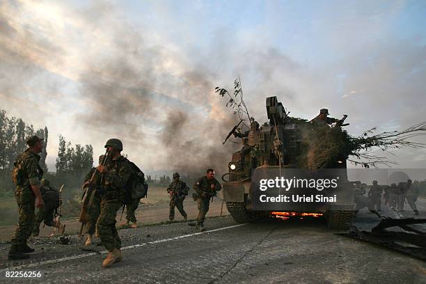 Georgian soldiers escape their burning armoured vehicle on the road to Tbilisi on August 11, 2008 just outside Gori, Georgia. Russia called today for...