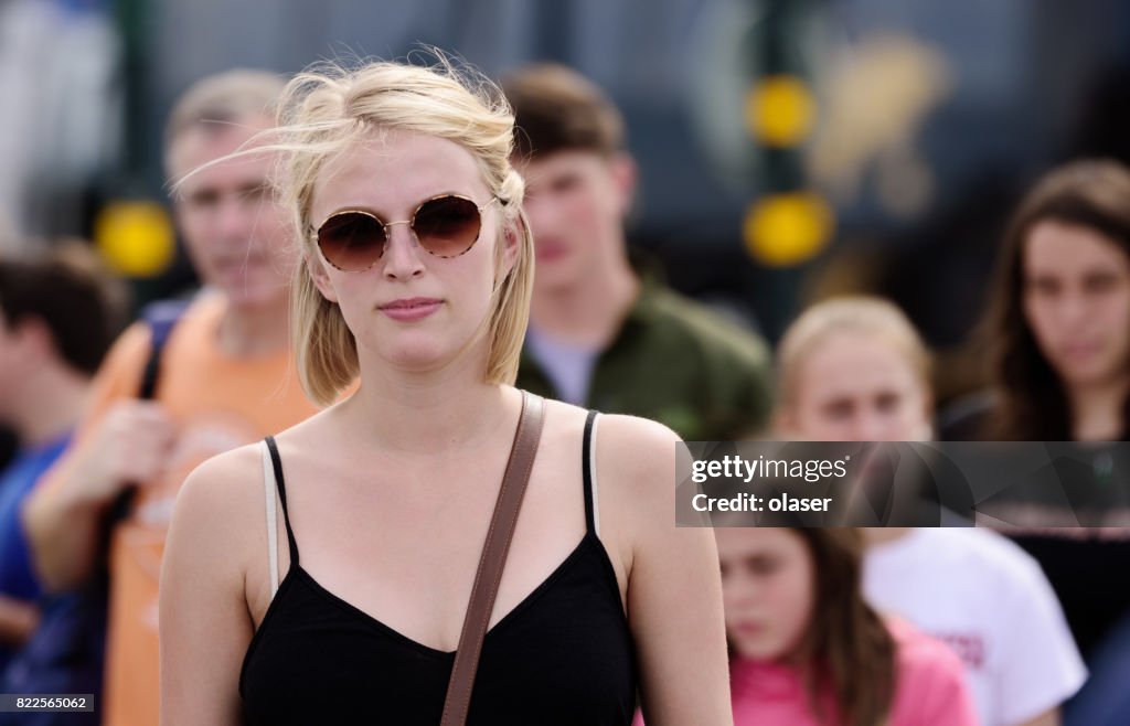 Blonde pedestrian woman walking in crowd