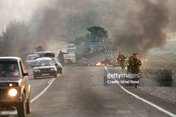 Georgian soldiers escape their burning armoured vehicle on the road to Tbilisi on August 11, 2008 just outside Gori, Georgia. Russia called today for...