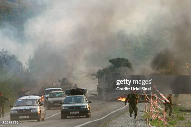 Georgian soldiers run from the scene of a destroyed armoured vehicle on the road to Tbilisi on August 11, 2008 just outside Gori, Georgia. Russia...
