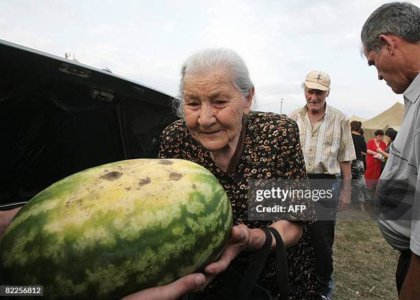 Refugee from South Ossetia takes a watermelon in a camp visited by French Foreign Minister Bernard Kouchner on August 11 near the village of Alagir,...