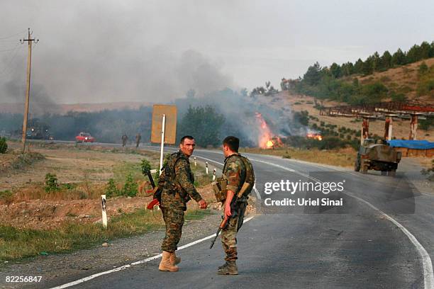 Georgian soldiers walk from the scene of a destroyed armoured vehicle on the road to Tbilisi on August 11, 2008 just outside Gori, Georgia. Russia...