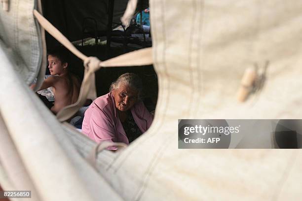 An elderly refugee from South Ossetia looks on as she sits under a tent in a camp visited by French Foreign Minister Bernard Kouchner on August 11...