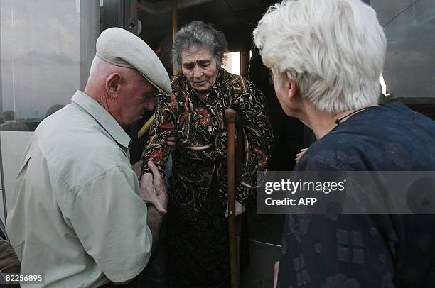 Man helps an elderly woman from South Ossetia in a camp visited by French Foreign Minister Bernard Kouchner on August 11 near the village of Alagir,...