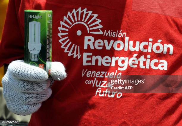 Member of the "Energy Revolution" project holds a low consumption light bulb in Caracas on August 8, 2008. The project, which is organized by the...