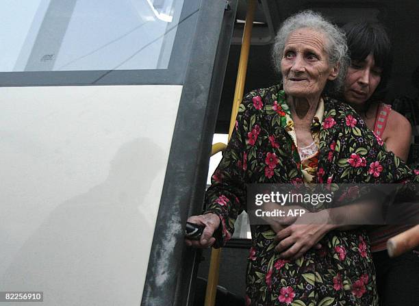 An elderly woman from South Ossetia looks on as she is helped in a refugee camp visited by French Foreign Minister Bernard Kouchner on August 11 near...