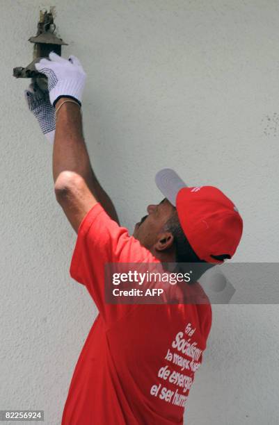 Member of the "Energy Revolution" project installs a low consumption light bulb in Caracas on August 8, 2008. The project, which is organized by the...