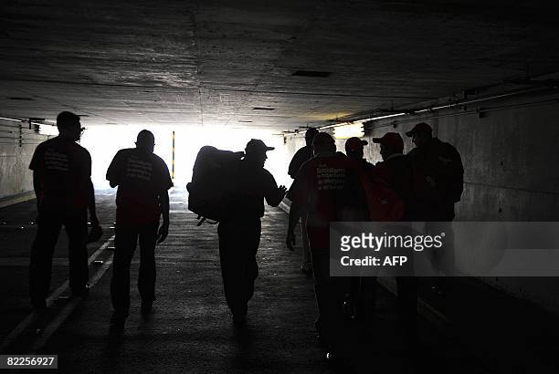 Member of the "Energy Revolution" project walk through a tunnel carrying low consumption light bulbs in Caracas on August 8, 2008. The project, which...
