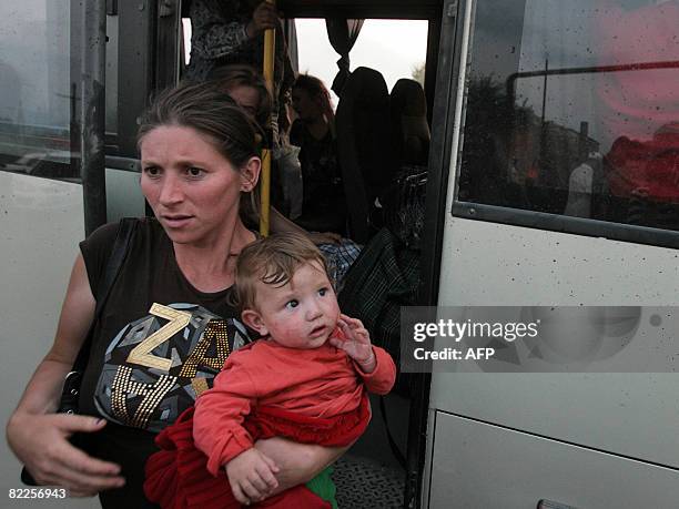 Woman from South Ossetia carries a baby as she arrives in a refugee camp visited by French Foreign Minister Bernard Kouchner on August 11 near the...