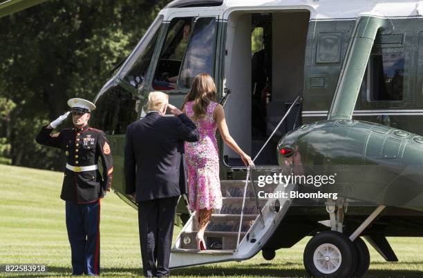 President Donald Trump, center, salutes while boarding Marine One with U.S. First Lady Melania Trump on the South Lawn of the White House in...