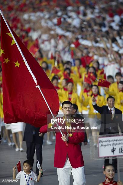 Summer Olympics: Team China national flag bearer Yao Ming with nine-year-old earthquake youth survivor Lin Hao and delegation during athlete...