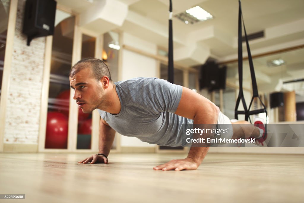 Hacer de hombre entrenamiento de suspensión TRX push ups