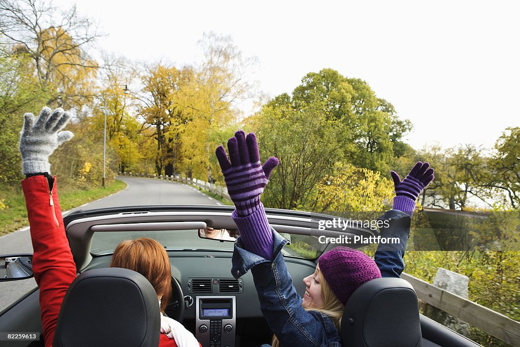 Two young women driving a cabriolet an autumn day Sweden.