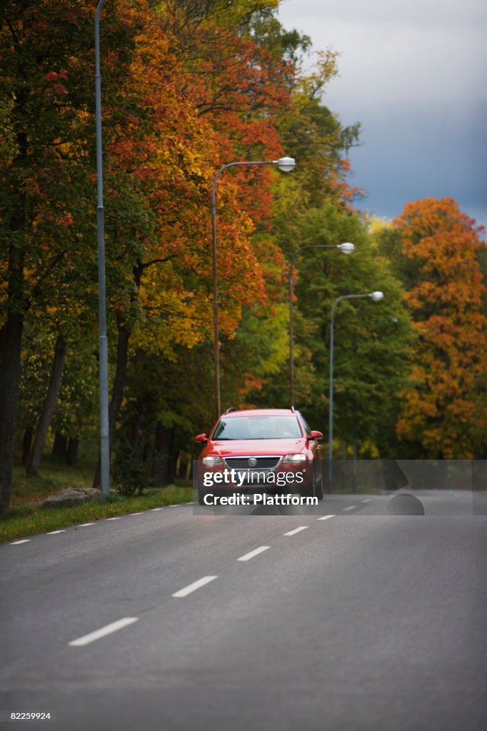 Red car on a countryroad Sweden.
