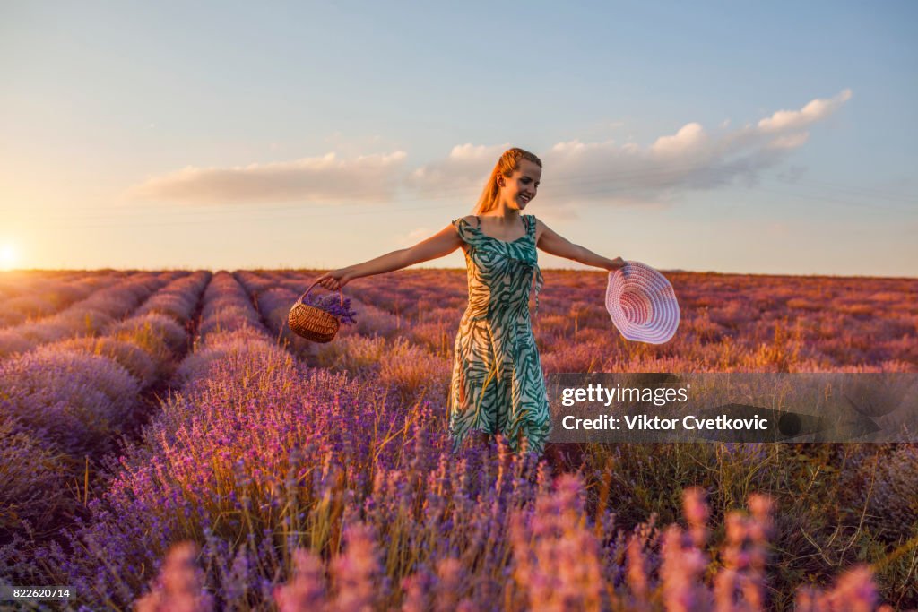 Chica joven en flores de color púrpura de la lavanda