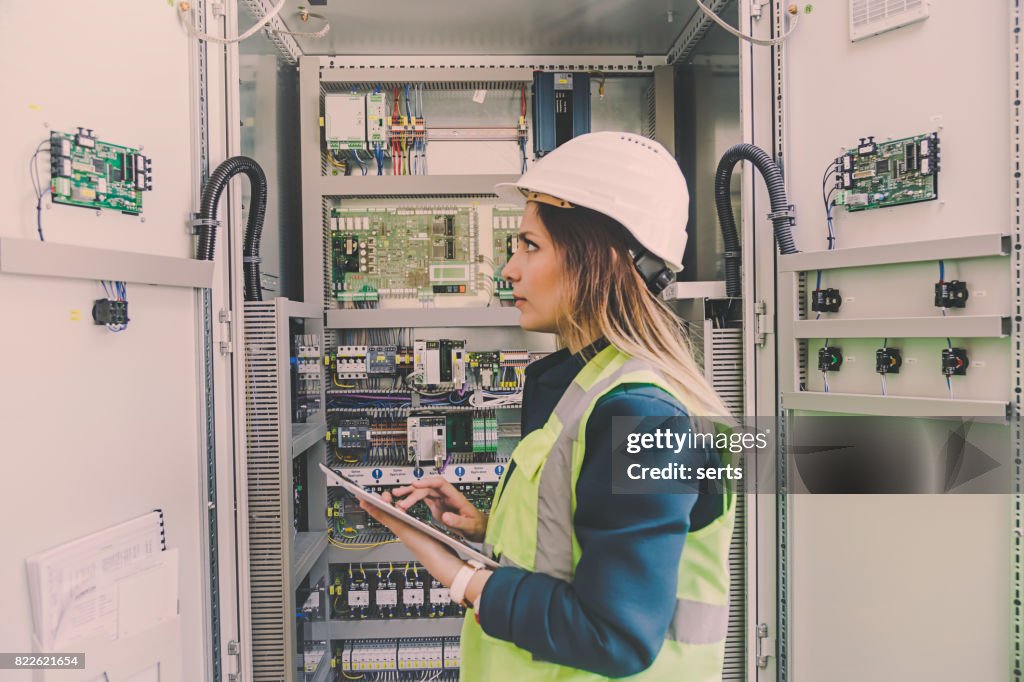 Female stationary engineer take notes at energy control room