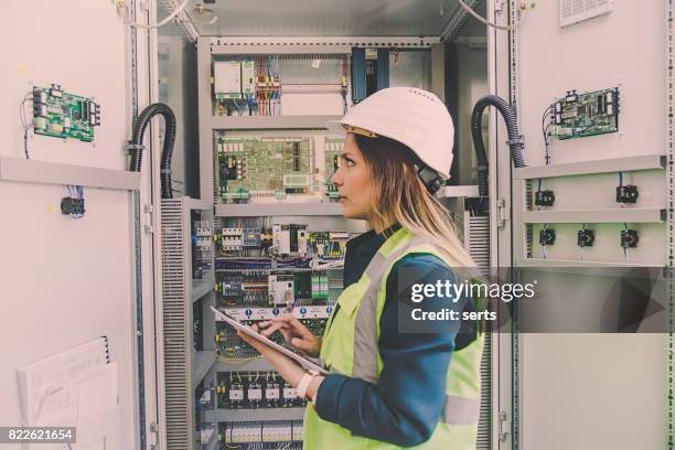 female stationary engineer take notes at energy control room - distribution board stock pictures, royalty-free photos & images