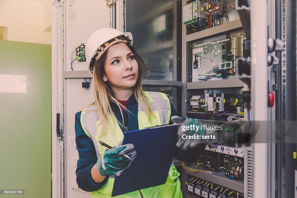 Vrouwelijke energie Station elektricien ingenieur werken bij energie controlekamer