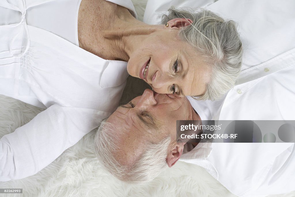 Senior couple lying head to head