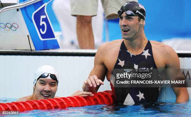 Swimmer Michael Phelps reacts as South Korea's Park Taehwan looks on after the men's 200m freestyle swimming final at the National Aquatics Center in...