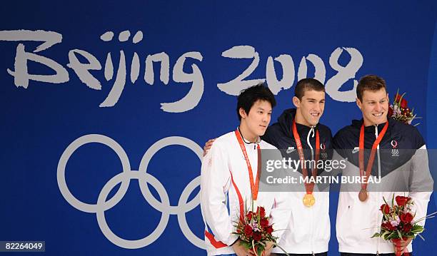 Swimmer Michael Phelps poses on the podium with South Korea's silver medalist Taehwan Park and bronze medalist Peter Vanderkaay of the US after the...