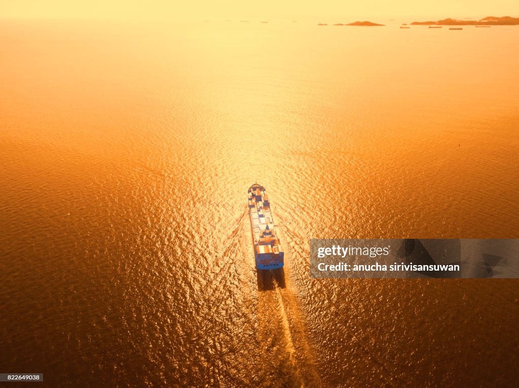 Container cargo Ship is running in sea orange light .