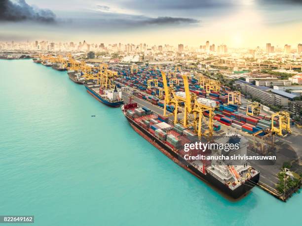 cargo ship container park at the pier near city at sunset . - unloading airplane stock pictures, royalty-free photos & images