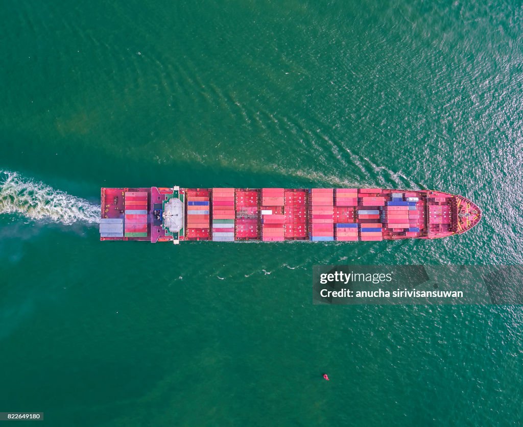 Aeriel view container shipping by container ship by green sea .